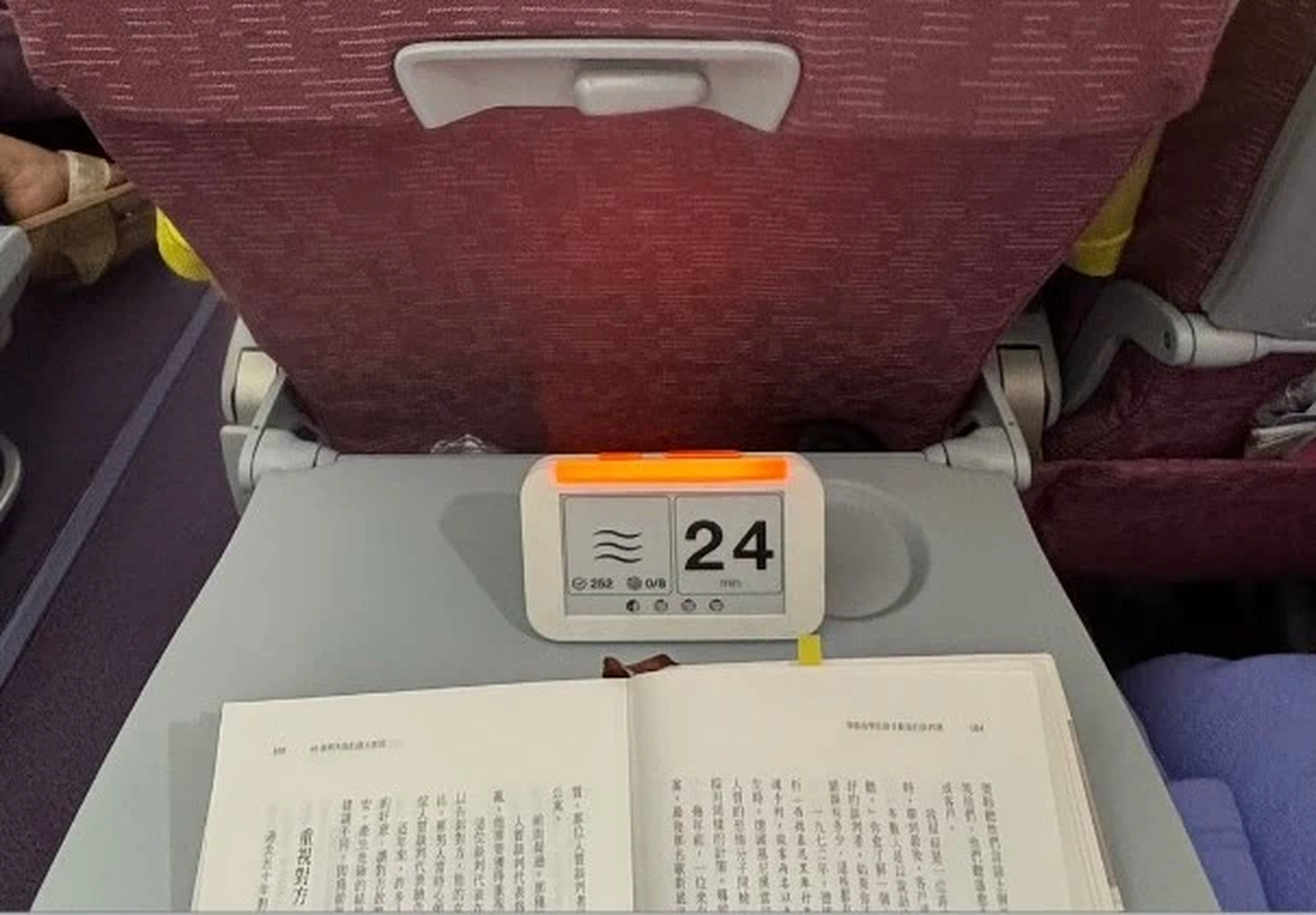 梁文宣在飛機座位上使用心流鐘，計時器顯示 24 分鐘 ON AIR 橘燈亮起，前方放著一本打開的中文書